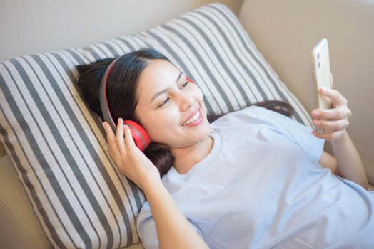 a young woman is using headset enjoying with music in living room , home safety concept photo