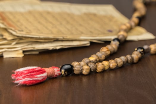 Muslim prayer beads with ancient pages from the Koran. Islamic and Muslim concepts. Ancient old sheets of paper from the Arabic book photo