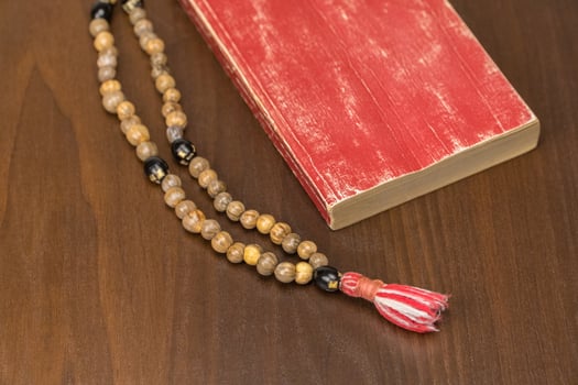 Muslim prayer beads and Quran isolated on a wooden background. Islamic and Muslim concepts photo