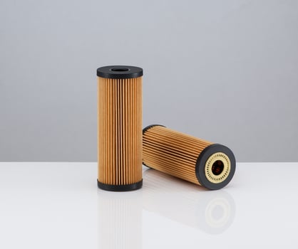 two automotive filter cylindrical shape of orange color on a white background photo