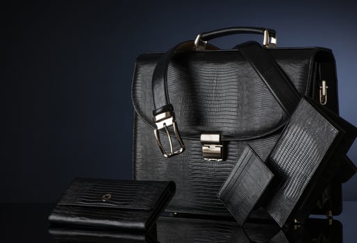 Fashionable men's set of leather accessories on a dark background. Briefcase, wallet, belt photo
