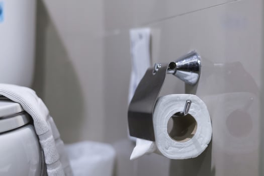 Clean toilet paper in the bathroom. Being folded and being used for the hotel guests photo