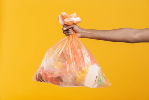 African woman holding orange plastic trash bag photo