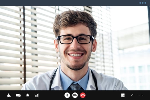 Young doctor smiling to the camera while making video call with patient online, home medical consulation service concepts photo