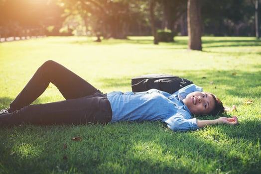Young hipster woman lying down on grass. photo