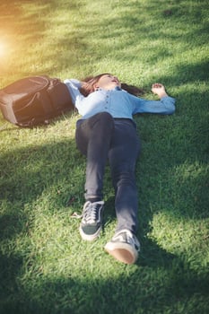 Young hipster woman lying down on grass. photo
