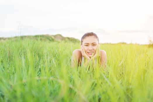 Beautiful Young Woman,Healthy Smiling woman Relaxing in Green Grass at meadows. photo