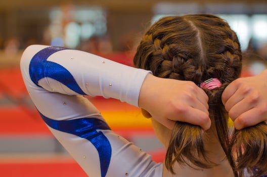 Young gymnast girl fixing hair before appearance photo