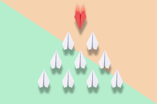 red paper plane leading white ones, leadership concept photo
