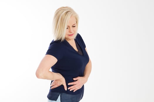 A woman suffering from severe pain in her tummy. Isolated on white. mature woman standing and having stomach ache, sick woman with menstruation pain, ill woman suffers from cramp, stomach ache, belly photo
