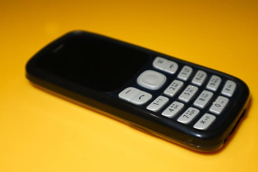 vintage mobile phone with copyspace on yellow background. photo