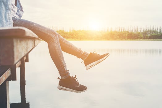 Hipster women feets laying on the lake relaxing with her holiday. photo