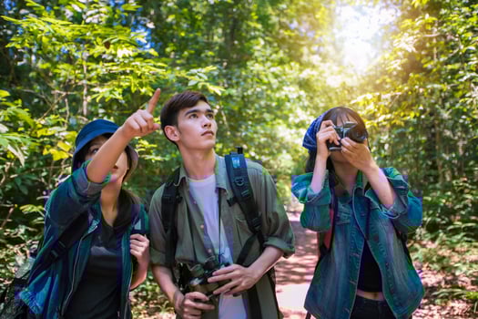 Asian Group of young people Hiking with friends backpacks walking together and looking map and taking photo camera by the road and looking happy ,Relax time on holiday concept travel