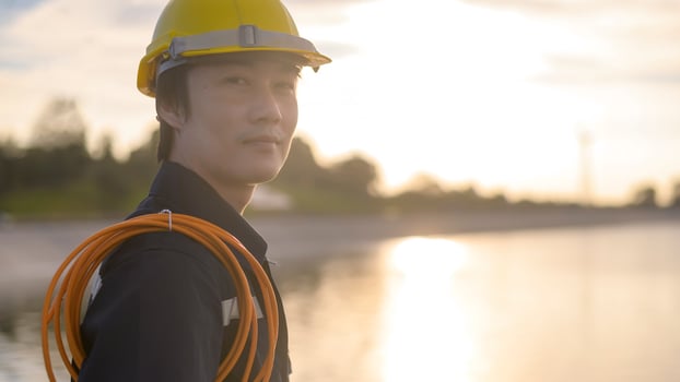 A male engineer wearing a protective helmet at sunset. photo
