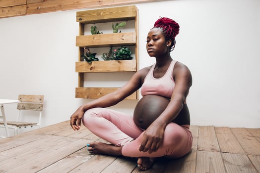 Black pregnant woman doing some ioga and meditation photo