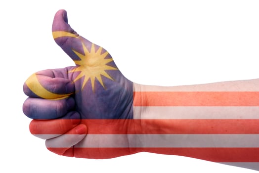 Concept Malaysia-the hand gives a thumbs up with the flag of Malaysia. photo