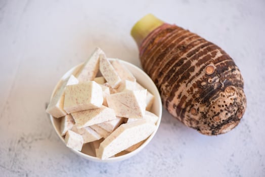 Taro root with slice cubes on bowl and table background, Fresh raw organic taro root ready to cook photo