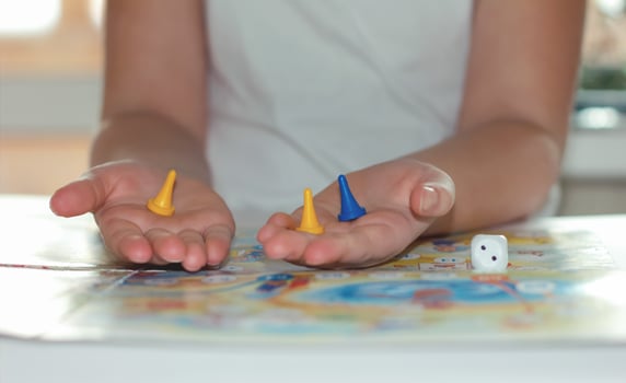 little girl playing board game. gaming chips in girl's hands photo