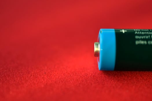 AA finger battery on a red background photo