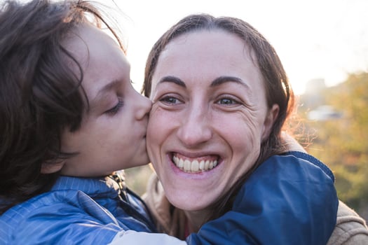Boy kisses and hugs mom, happy motherhood photo