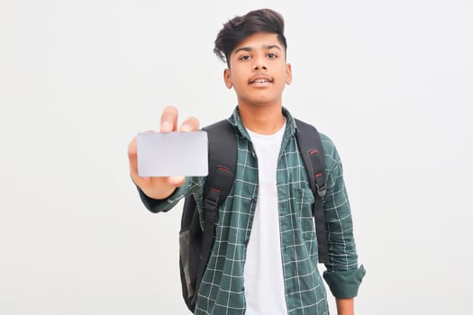 Young indian man showing debit or credit card on white background. photo