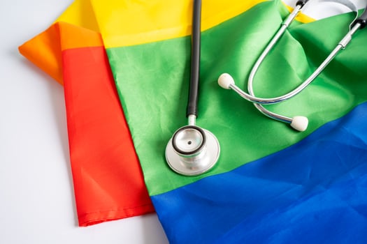 Black stethoscope on rainbow flag background, symbol of LGBT pride month  celebrate annual in June social, symbol of gay, lesbian, bisexual, transgender, human rights and peace. photo