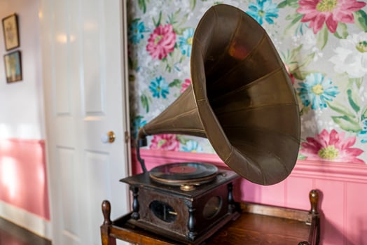 Old gramophone on table against decor wall photo