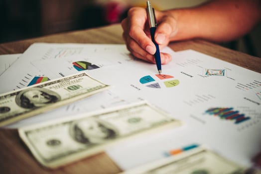 Working place of trader. The table covered by cash notes, keyboard and financial charts. Business financial working. photo