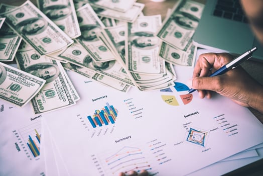 Working place of trader. The table covered by cash notes, keyboard and financial charts. Business financial working. photo