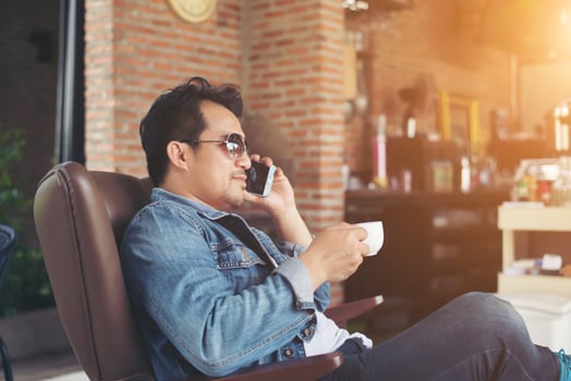 Young man with smartphone smiling relaxing at cafe. photo