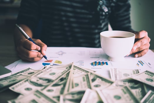 Working place of trader. The table covered by cash notes, keyboard and financial charts. Business financial working. photo
