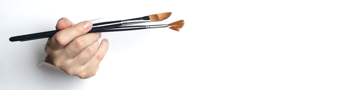Female hand holding a brush, on a white background. Copy Space. photo