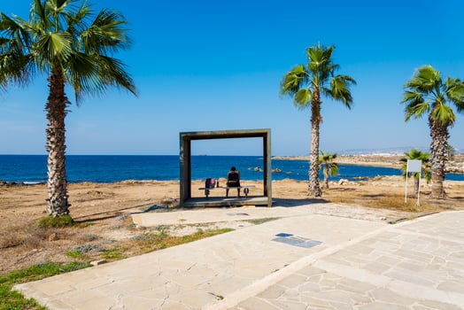 A man sitting on a bench overlooking the sea island of Cyprus. photo