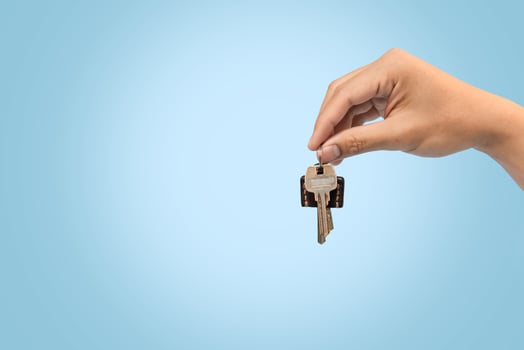 Hand holding keys blue background for refinance plan and real estate concept. photo