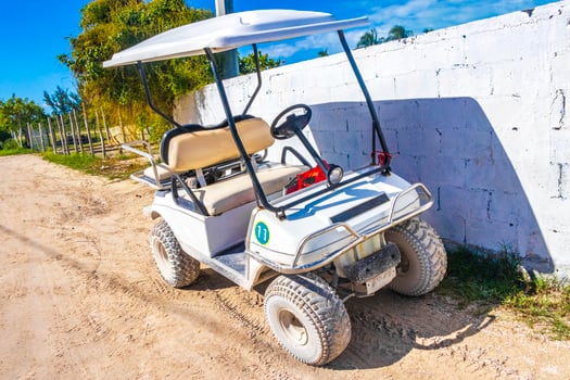 Golf cart buggy cars carts muddy street village Holbox Mexico. photo