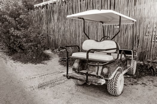 Golf cart buggy cars carts muddy street village Holbox Mexico. photo