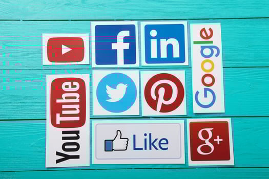 KIEV, UKRAINE - MARCH 10, 2017. Collection of popular social media logos printed on paper YouTube,Facebook, Twitter, Google Plus, Yahoo, Linkedin, Dropbox and like on blue wooden background. photo