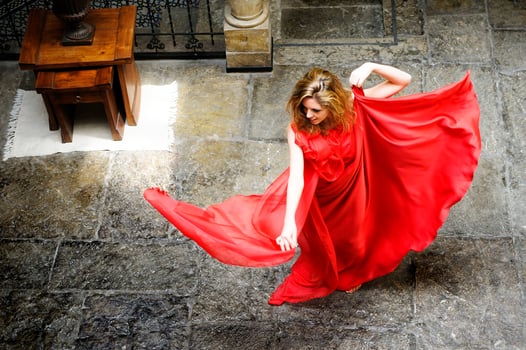 Beautiful blonde woman, wearing a red dress, jumping photo