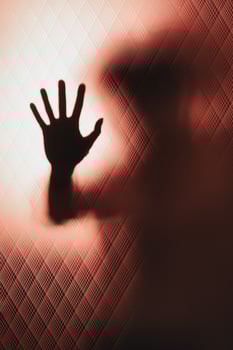 Behind glass door a leaning woman's hand asks for help photo