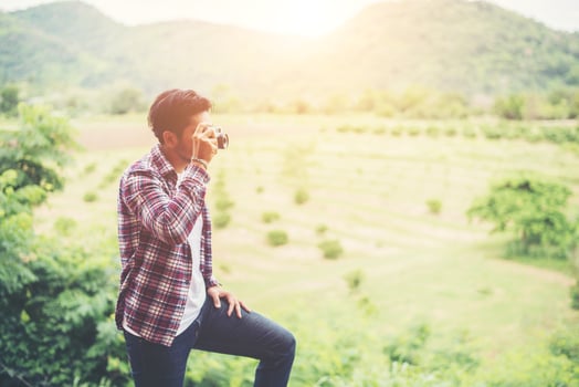 handsome hipster bearded man with cup of morning coffee walking in park. photo