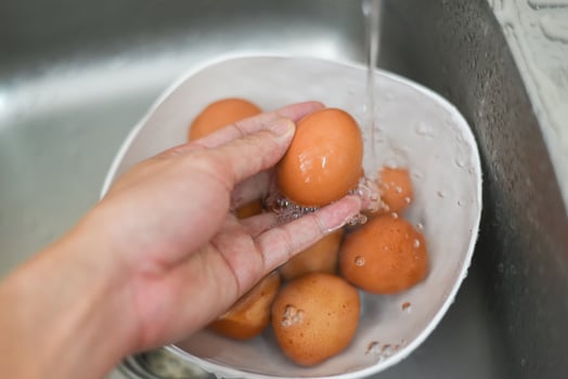 Wash the eggs, hand washing eggs on bowl at the sink clean chicken eggs fresh photo