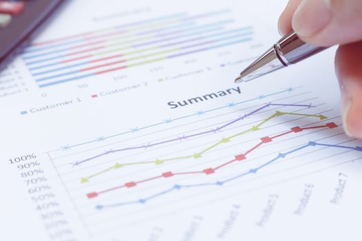 Close up businessman holding pen is on summary report and calculator. Business concept. photo