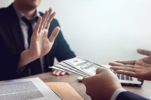 Businessperson refusing bribe given money by partner with anti bribery corruption concept. photo