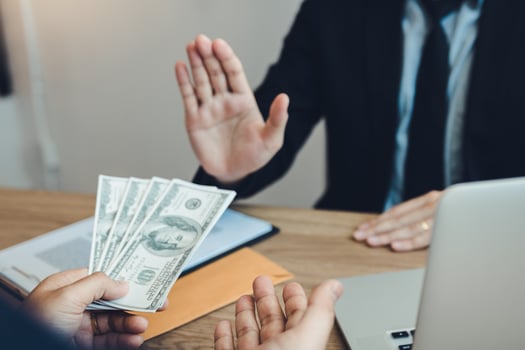 Businessperson refusing bribe given money by partner with anti bribery corruption concept. photo
