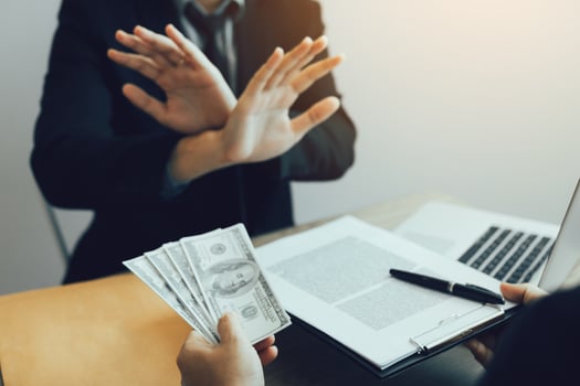 Businessperson refusing bribe given money by partner with anti bribery corruption concept. photo