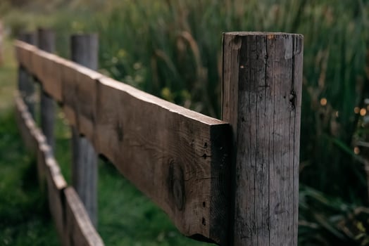 Wooden rural fence on a background of green grass photo
