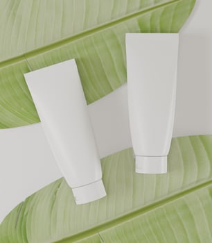 A mock up of couple realistic white blank cosmetic tube isolated on white background with leafs, 3d rendering , 3D illustration photo