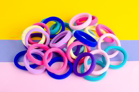 Colored hair ties on bright background. Photo