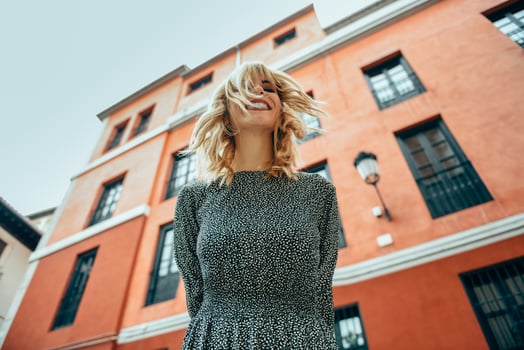 Happy young woman with moving hair in urban background. photo