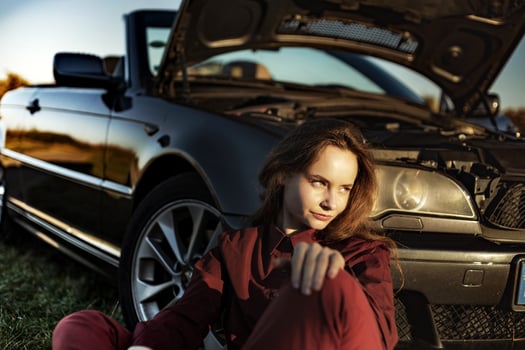A beautiful girl near a car broken down in a field, a retro convertible photo